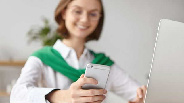 Recepção de clínica com um celular exibindo lembretes de consulta