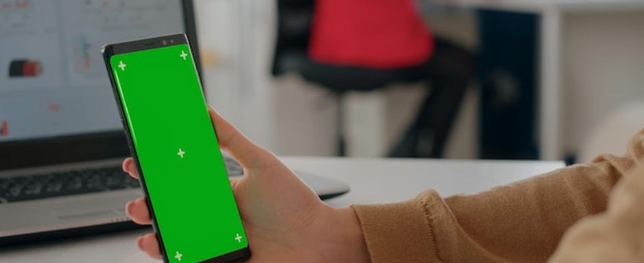 Equipe analisando gráficos e relatórios em dois monitores, revisando os dados da empresa antes de usar inteligência artificial